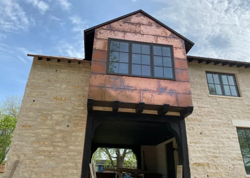 Copper metal panel facade on a stone building for Roof Repair in Leander